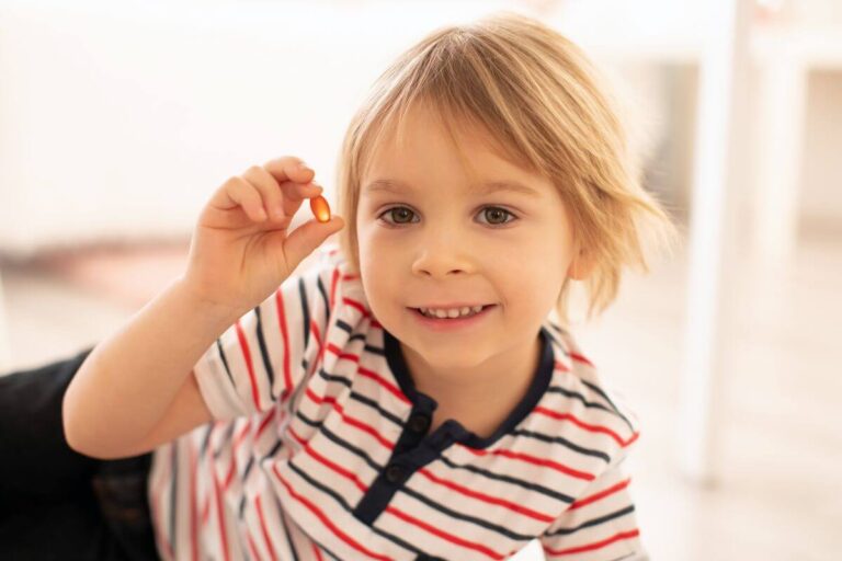 Criança com cápsula de ômega 3