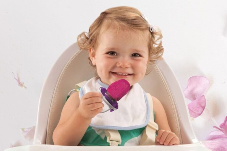 Bebê sorrindo com redinha de alimentação no cadeirão