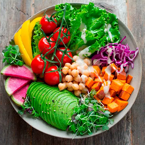 Prato vegano com abacate, grão-de-bico, tomate, abóbora, folhas e rabanete