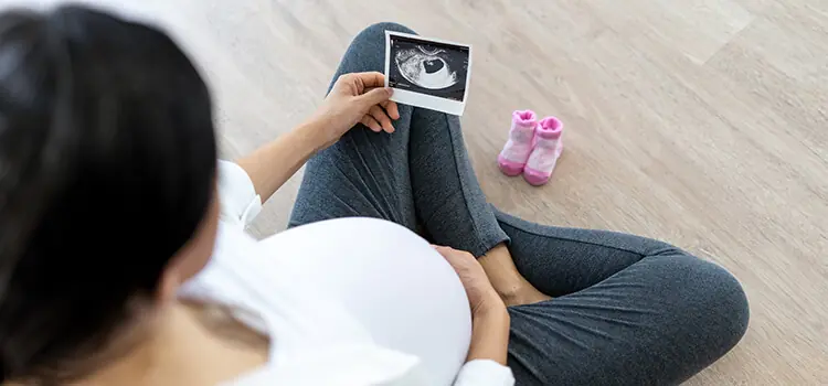 Gestante olhando o ultrassom do bebê com RCIU