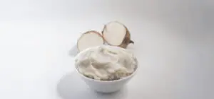 Inhame pode melhorar a Fertilidade? Imagem de um inhame cortado ao meio e um recipiente com purê de inhame.