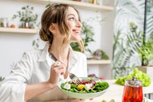 Mulher comendo feliz após realizar a implantação do embrião