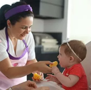 Nutricionista oferecendo laranja bebê