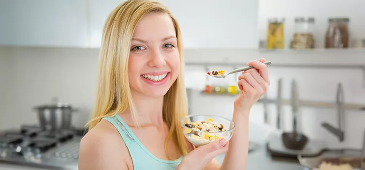 Mulher feliz com um café da manhã saudável para aumentar a Fertilidade